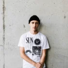 Male model wearing white SUN graphic T-shirt with contemporary black artwork print